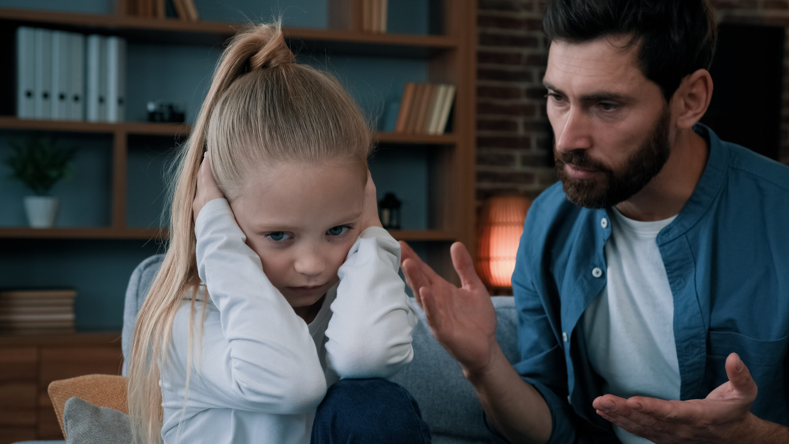 Sad offended little child daughter feel stress cover ears ignoring scream caucasian angry annoyed man dad shouting on girl for bad behavior and disobedience scolding kid problem of parenting in family.