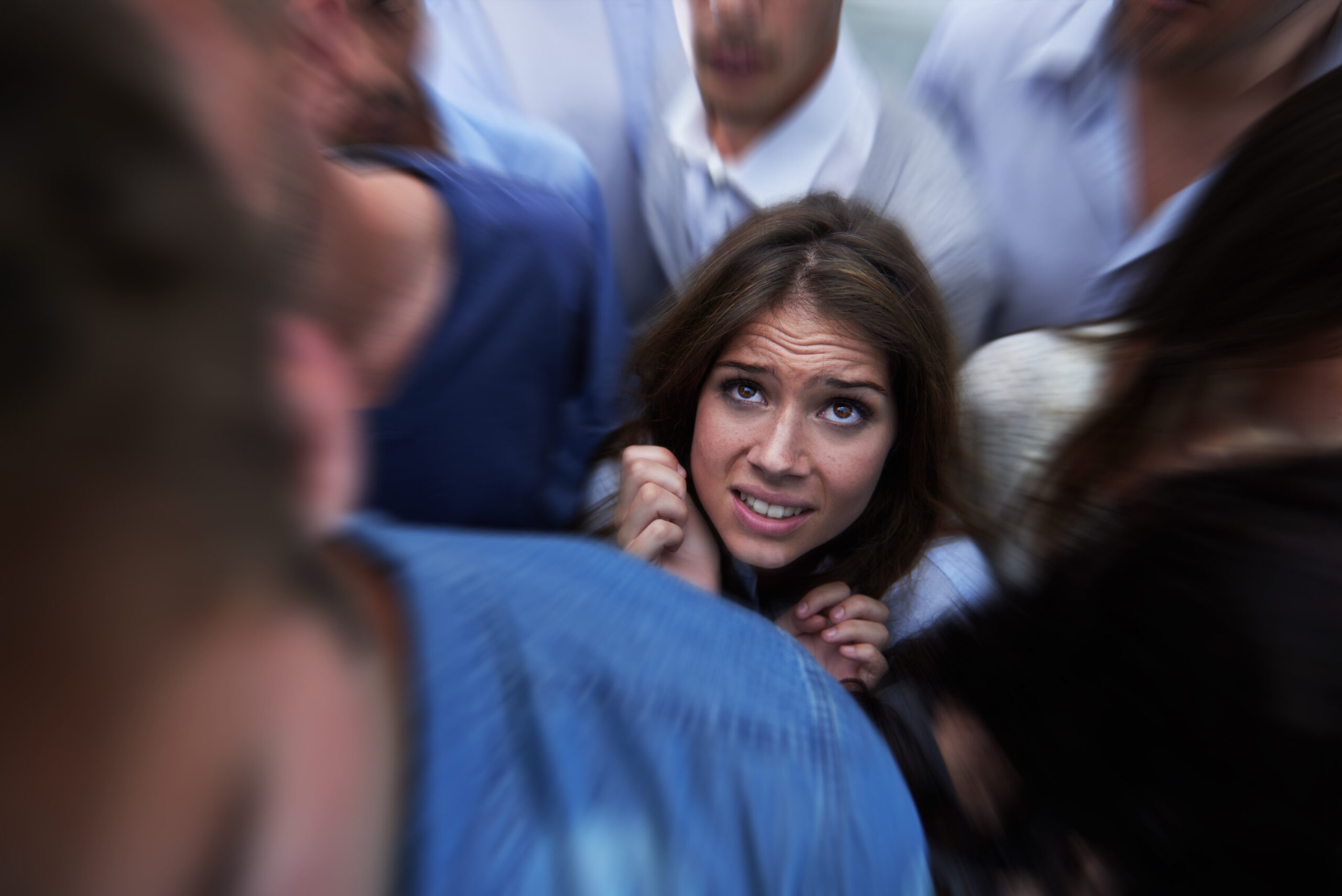 Drowning in people. Shot of a fearful young woman feeling trapped by the crowd
