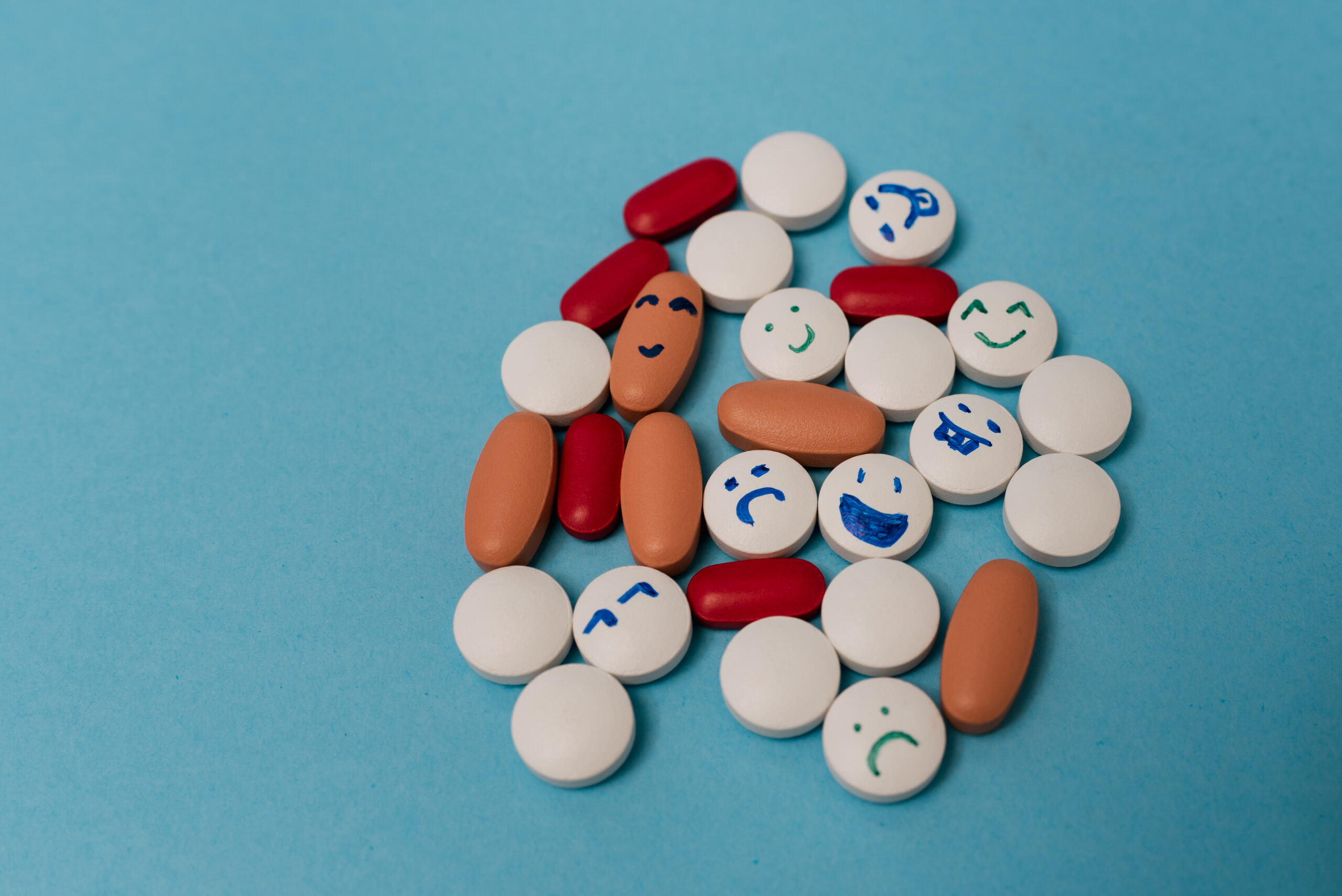 Stock photo of colored pills on a blue background. There is nobody on the picture.