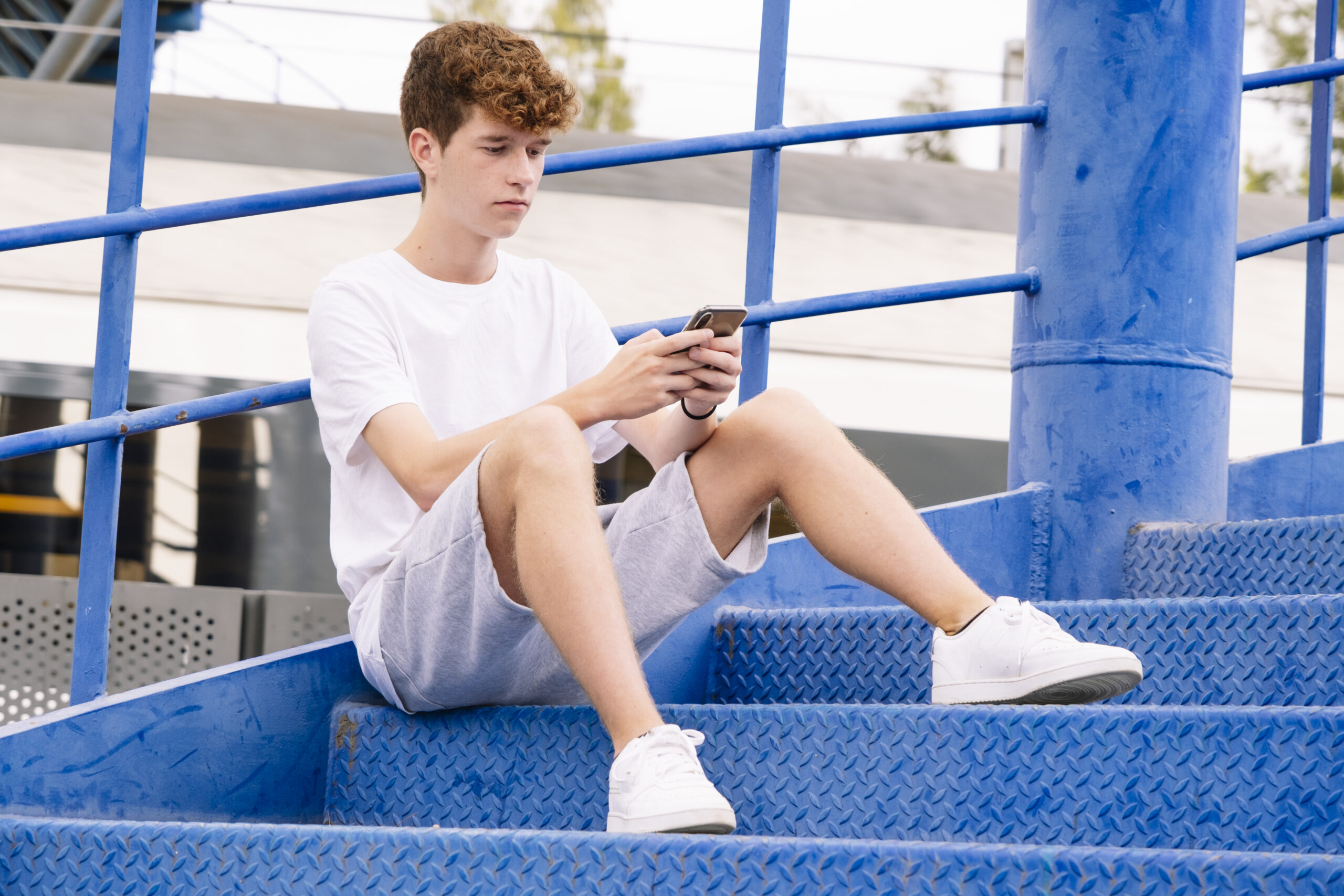 Teenager looking at the phone while waiting for someone