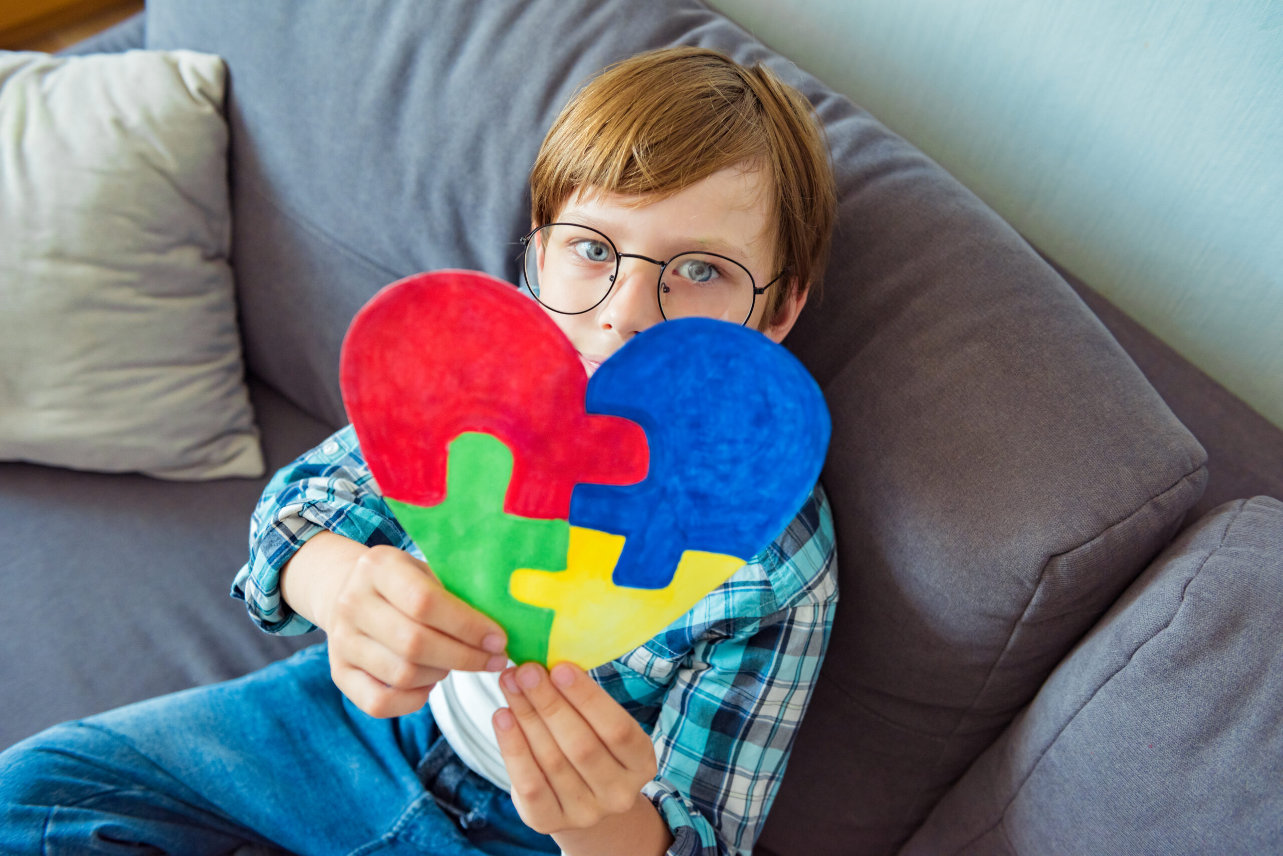 Young boy holding puzzle jigsaw, child mental health concept, world autism awareness day, autism spectrum disorder awareness concept