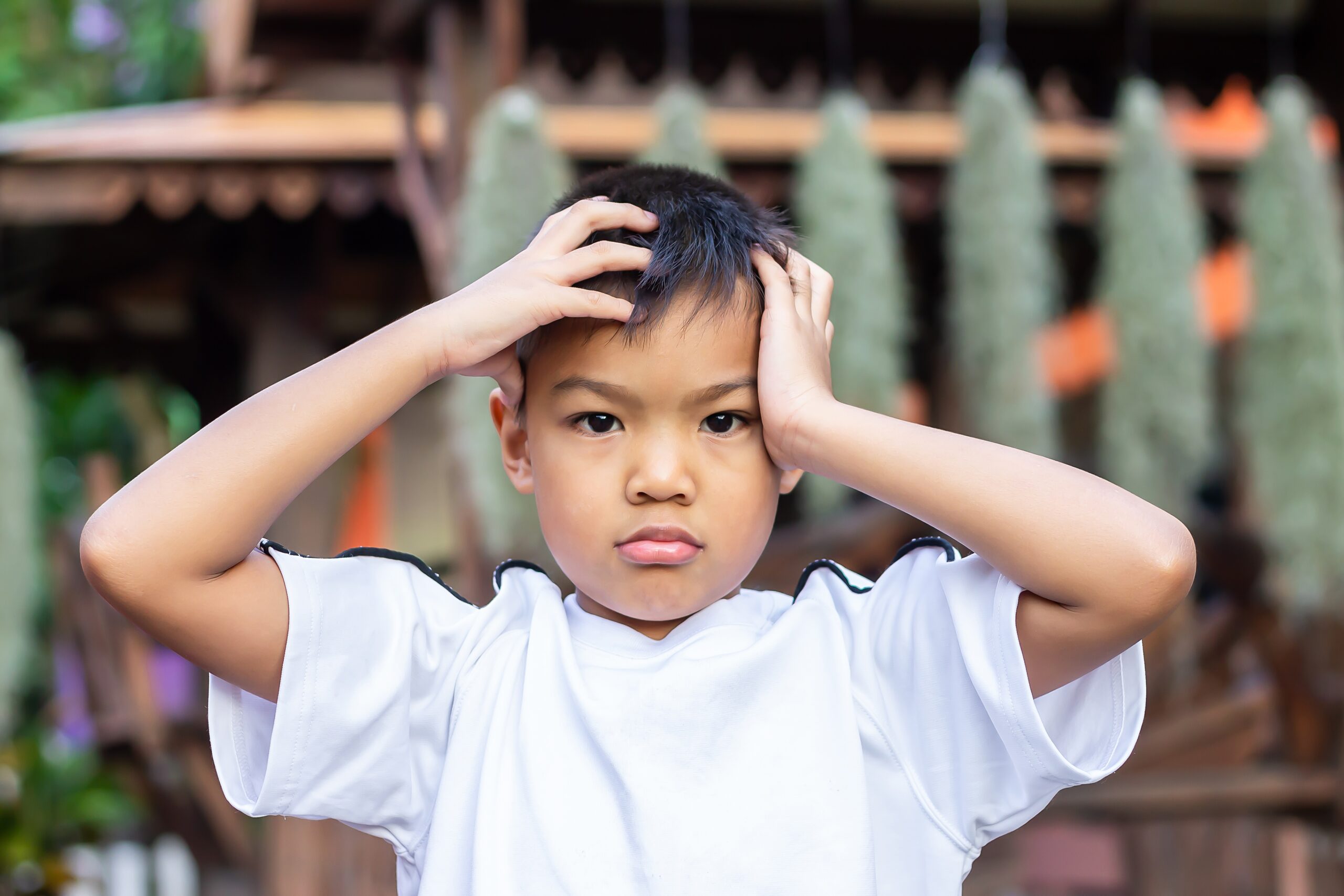 6-7​ years​ old​ child.​ Alone​ Asian​ little​ boy​ feel​ sad, headache and​ stressed.​ He​ lonely at​ the​ playground.​ Unhappy kid.​ Mood and​ emotions.