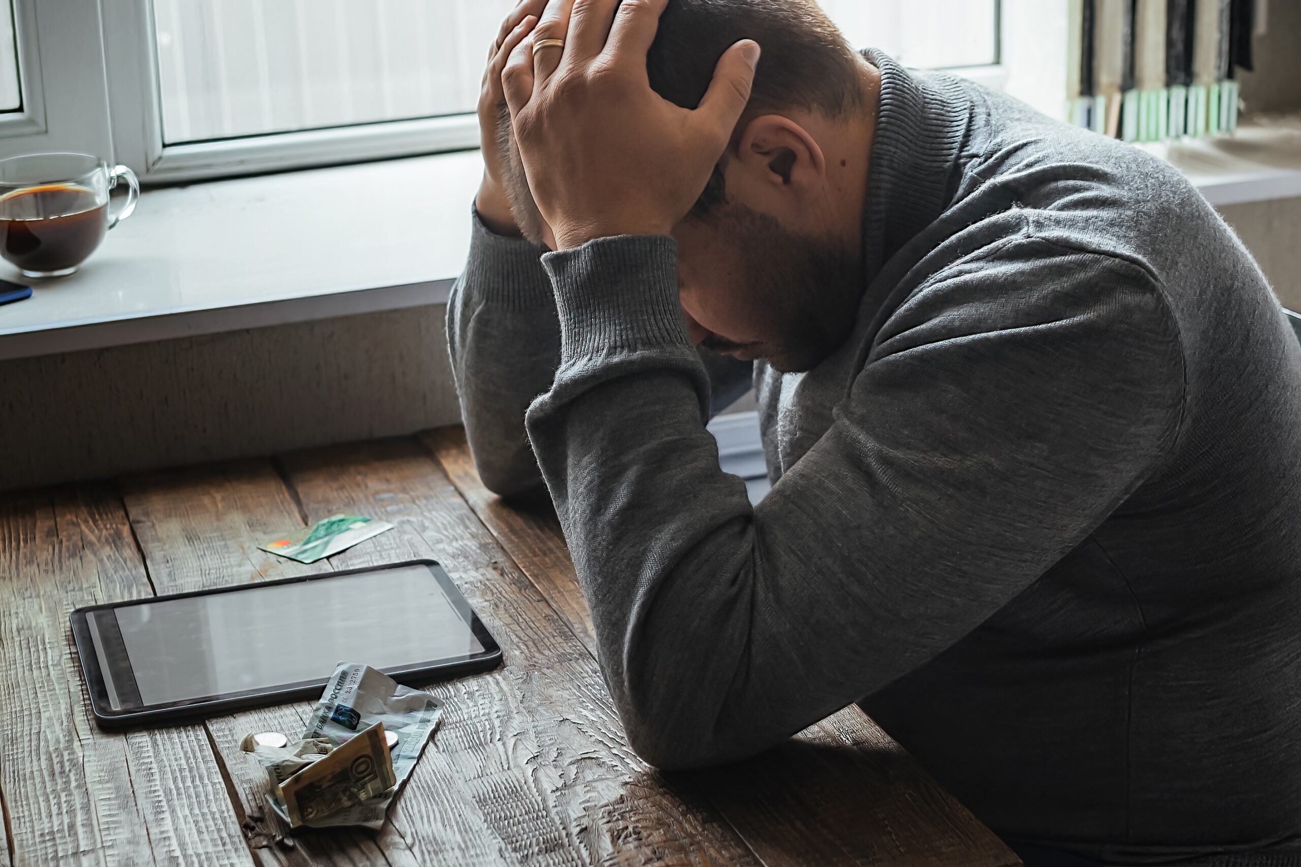 man sitting with head in hands stressed because his mental health isn't in a good spot