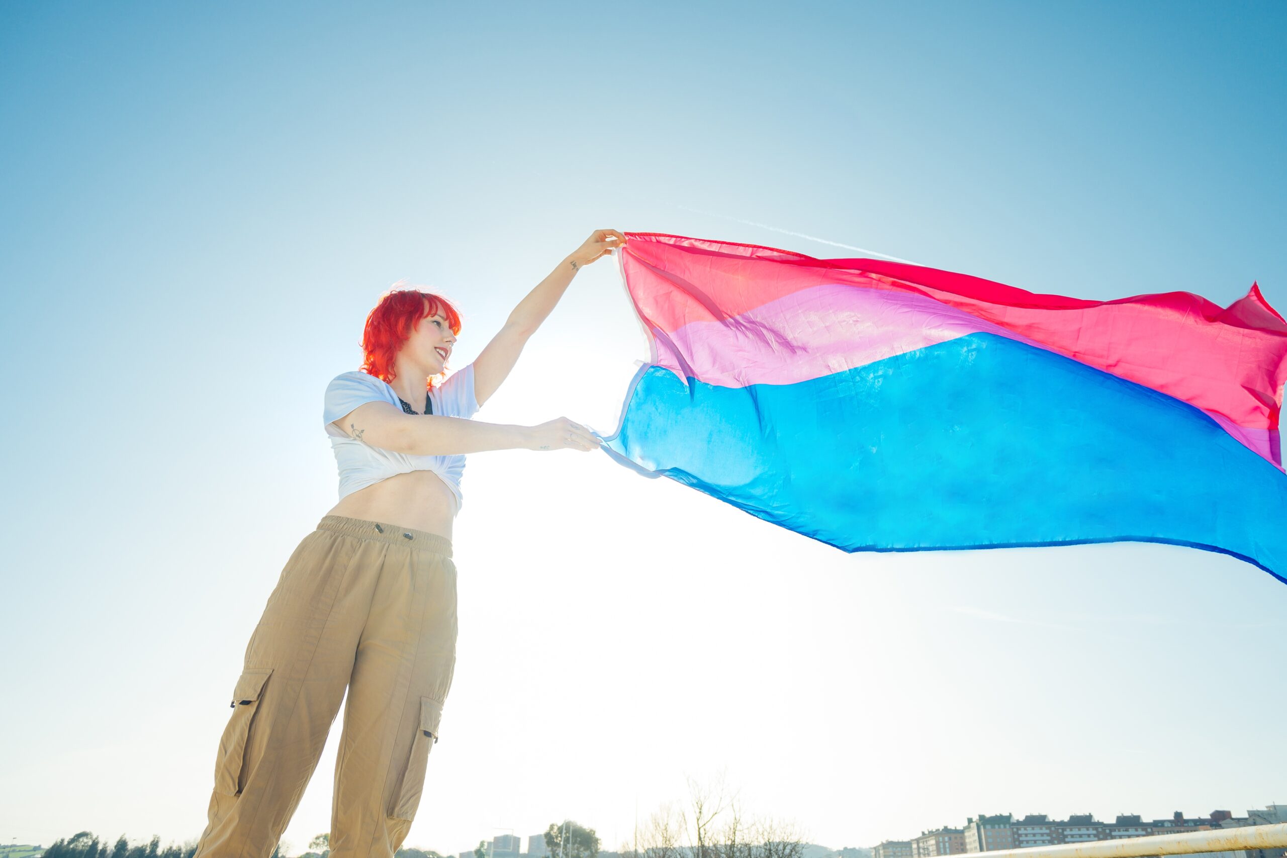 A beautiful shot of a red hair female waving blue and red flag