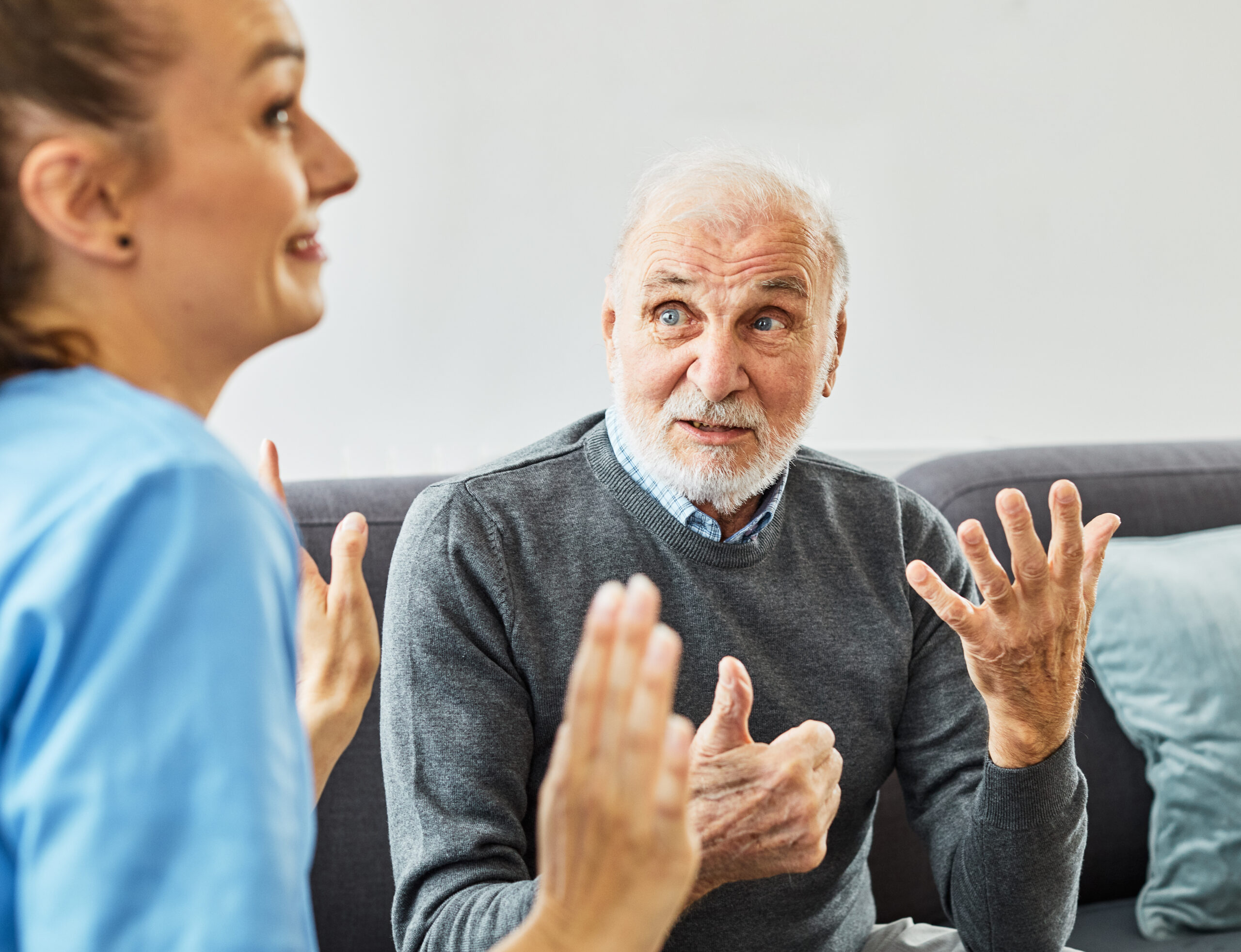 Doctor or nurse caregiver with sad lonely senior man at home or nursing home