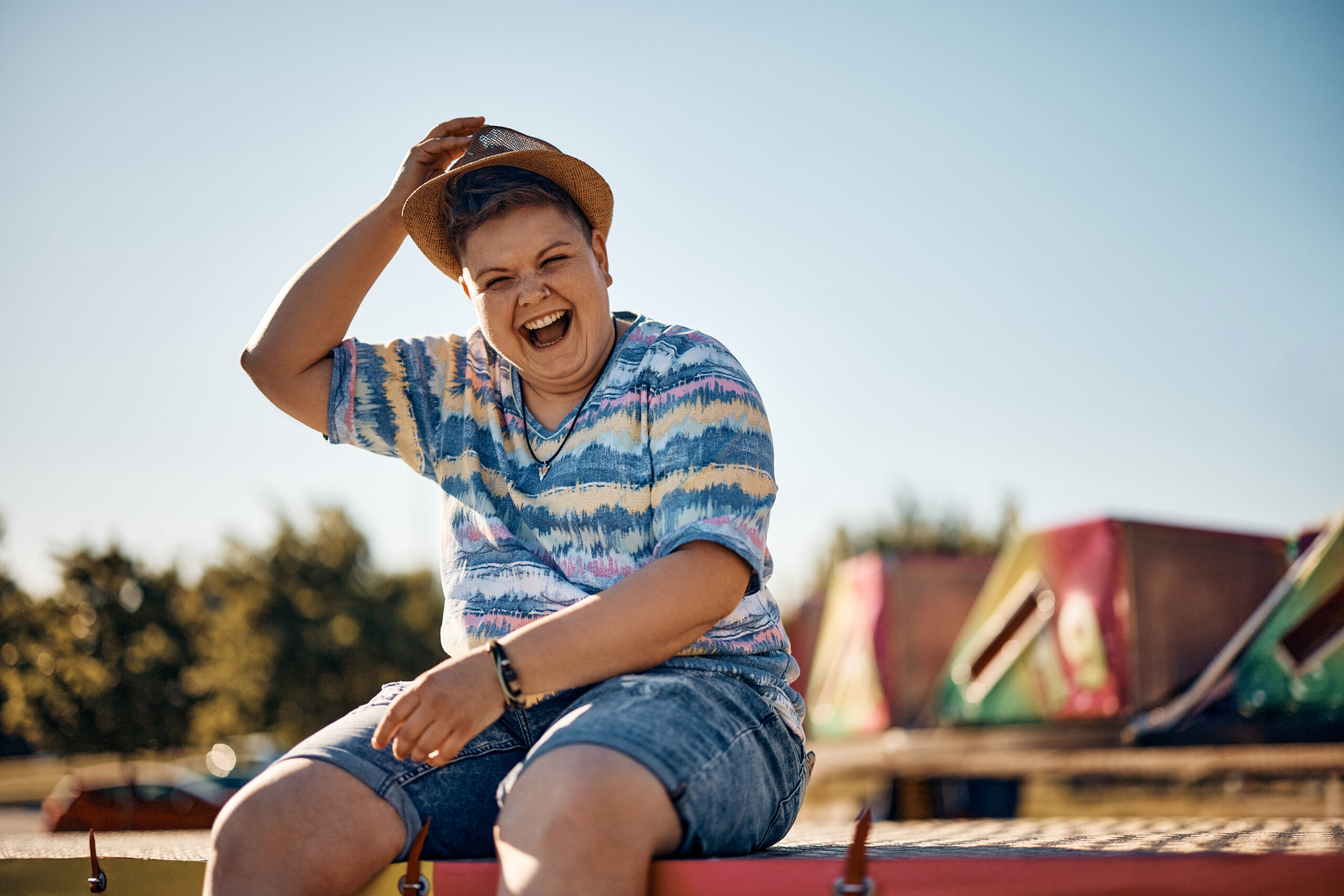 Happy woman having fun and laughing while relaxing at amusement park and looking at camera.