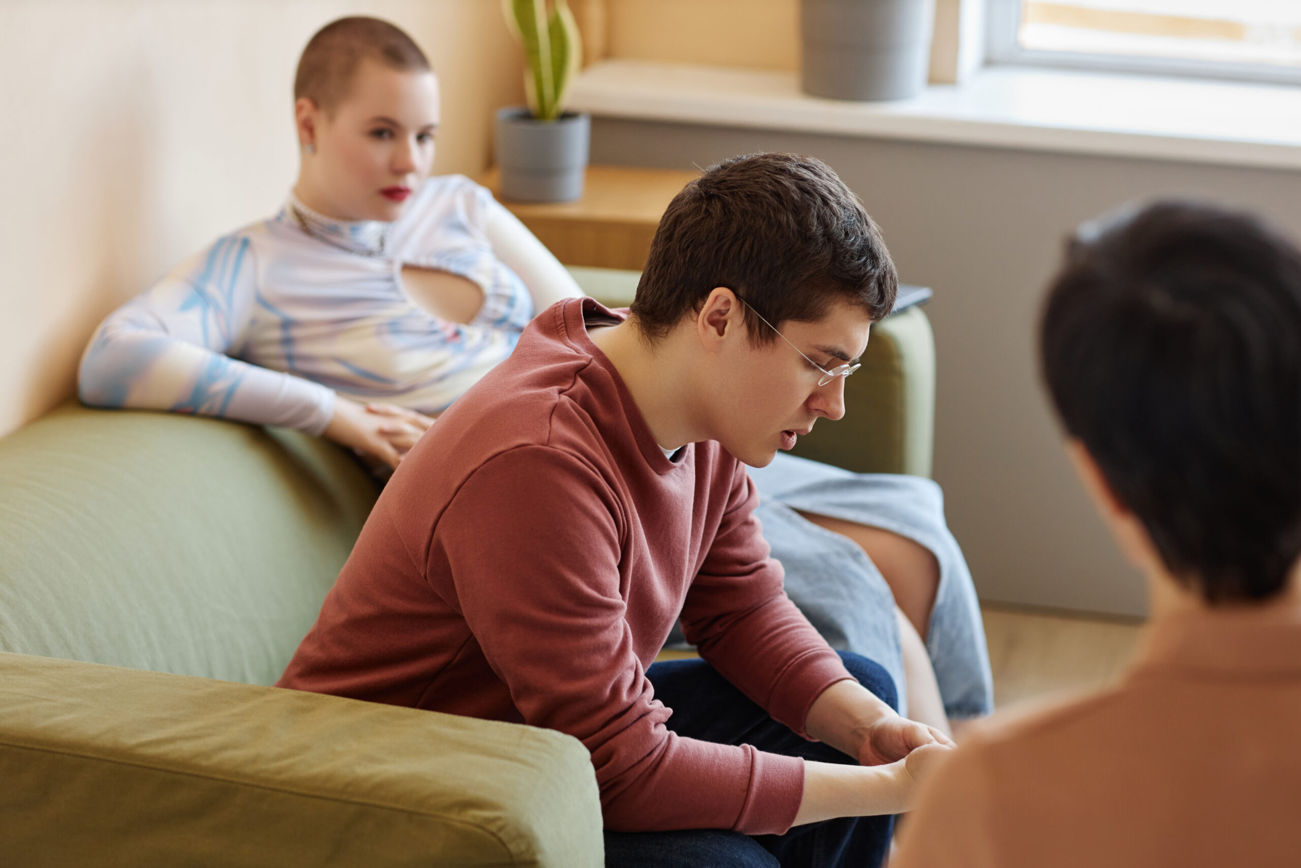 Young couple discussing problems with psychologist during session in office
